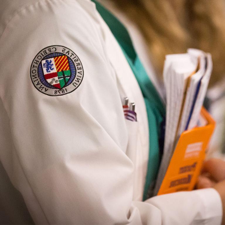 Closeup of the 皇冠体育博彩大学 crest on the sleeve of a medical student's white coat